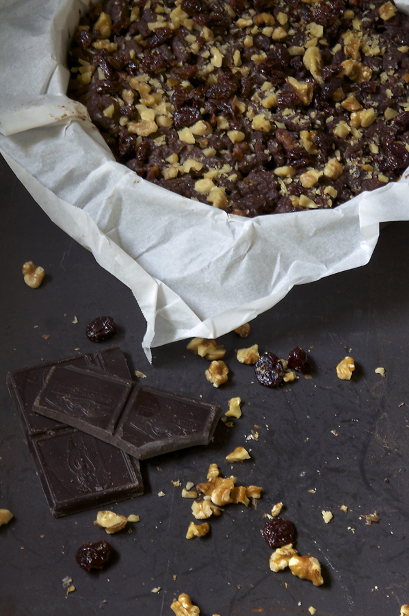 A chocolate, biscuit cookie cake with dried cherries and walnuts.