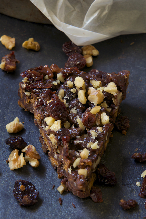 A chocolate, biscuit cookie cake with dried cherries and walnuts.